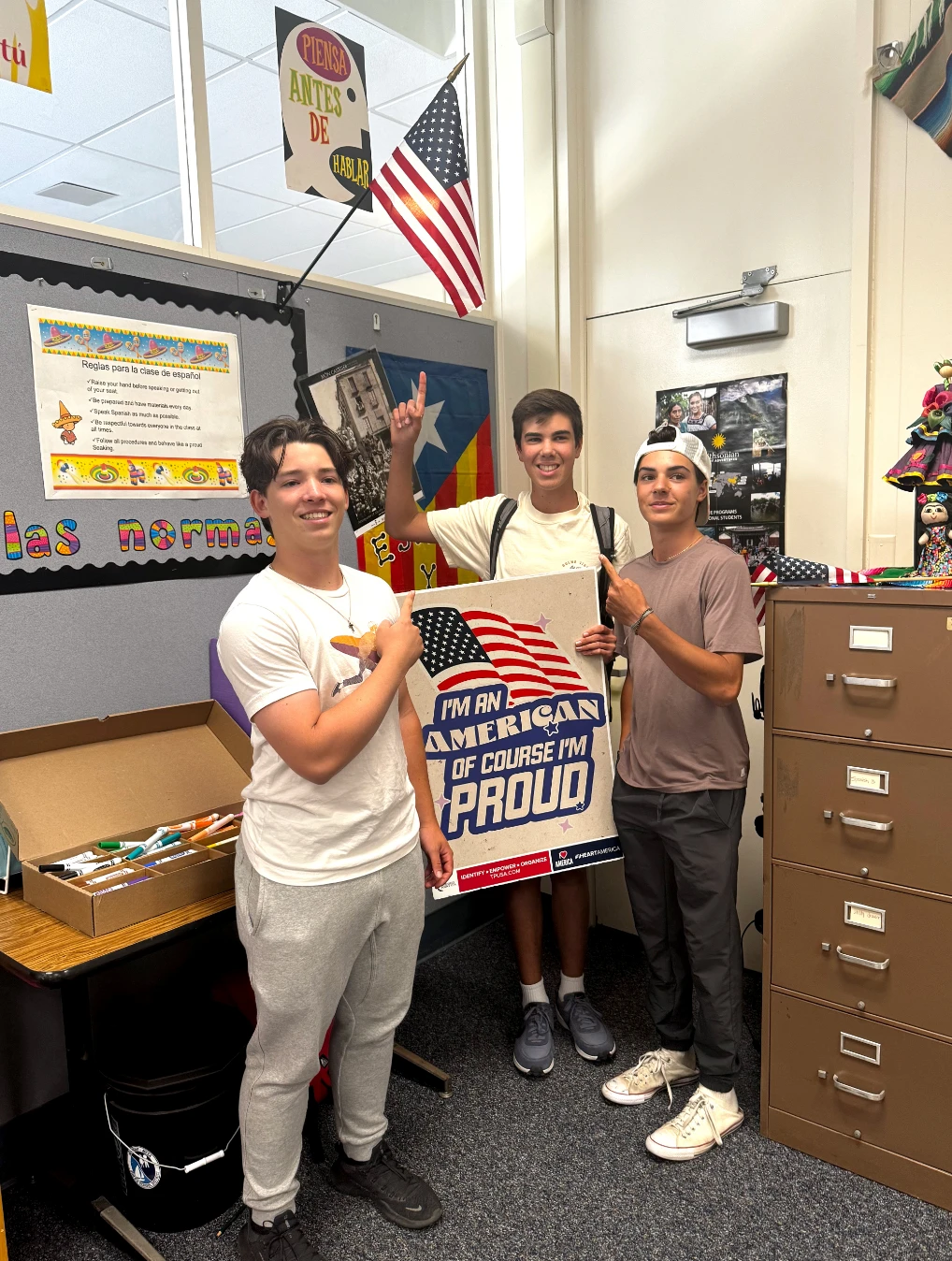 Students in a classroom holding a poster.