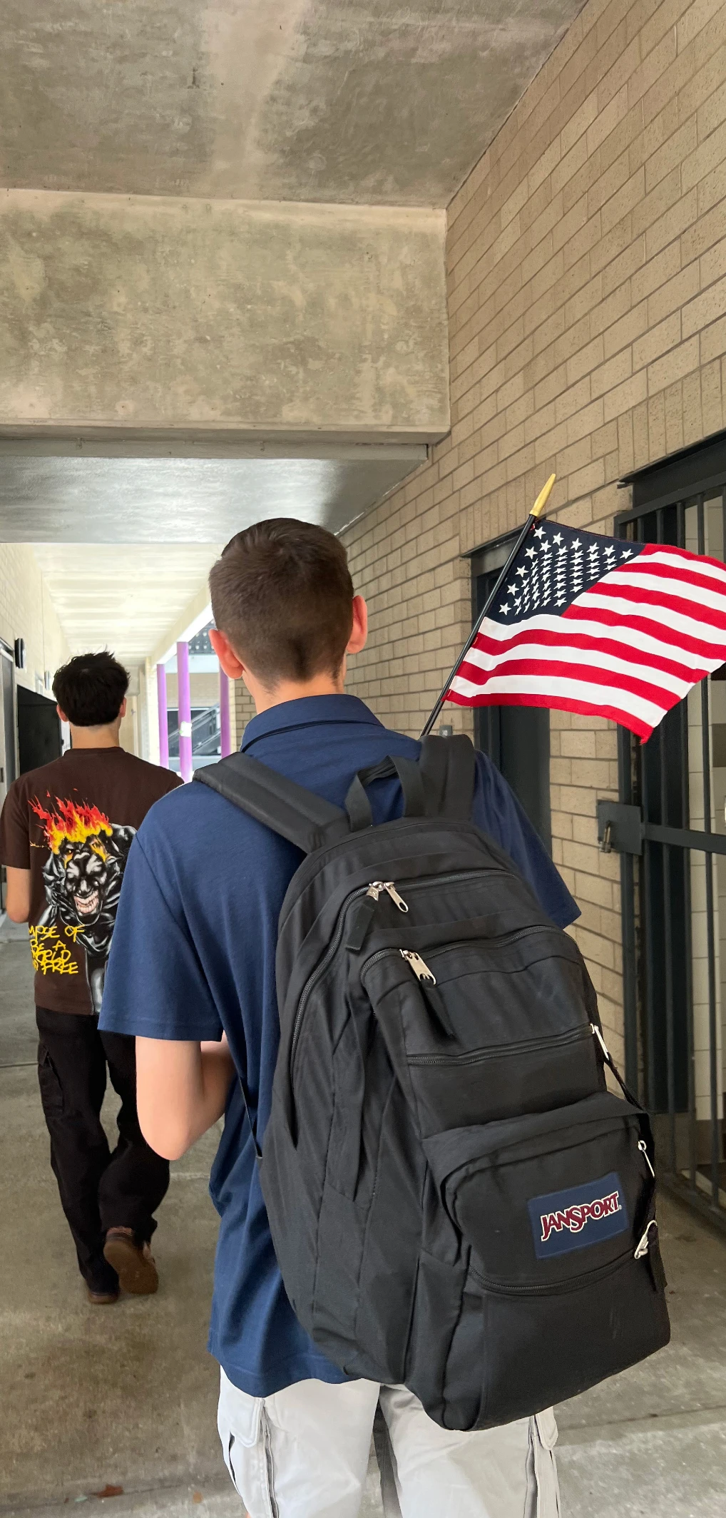 Student with a backpack featuring a USA flag.